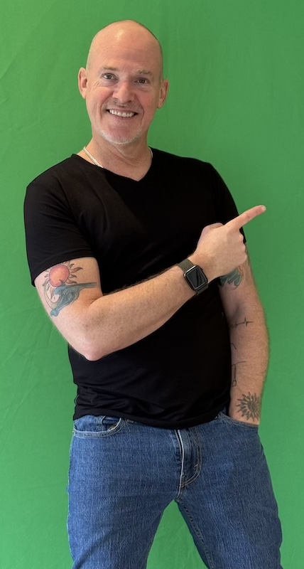 Ross smiling in front of a green background